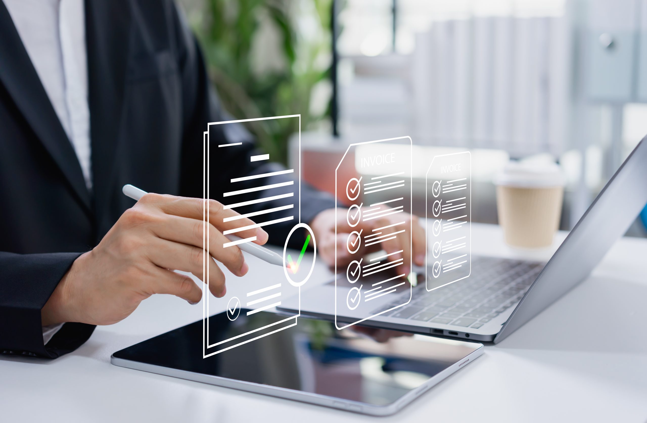 Businessman approving digital invoice on tablet and laptop, paperless billing system, e invoice management, and efficient online finance workflow.